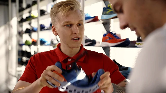 enthusiastic Intersport apprentice, selling shoes to a customer